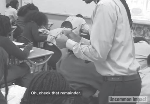 Photo depicts a student making tiny and quick notations as he circulates.
